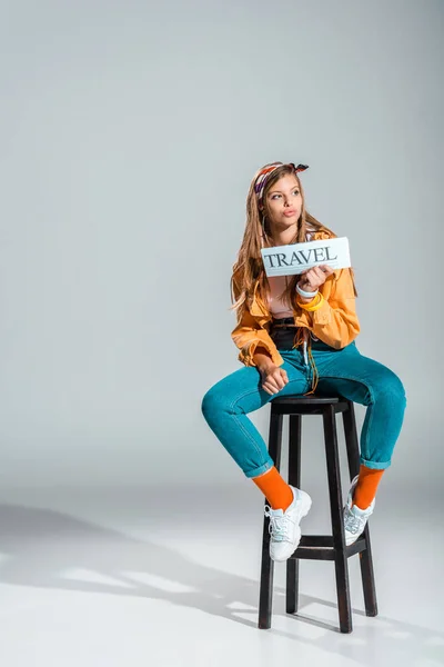 Stylish Girl Holding Travel Newspaper While Sitting Stool Grey Copy — Free Stock Photo