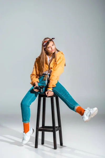 Smiling Stylish Photographer Holding Camera While Sitting Stool Grey — Free Stock Photo