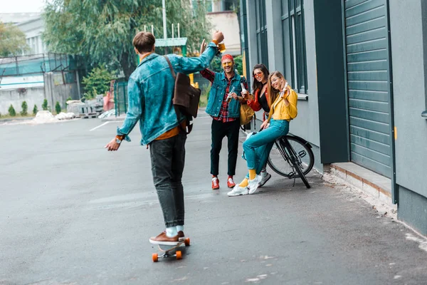 happy hipsters with skateboard and bicycle on street
