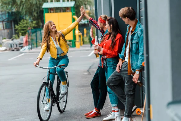 Happy Stylish Girl Riding Bike Giving Highfive Friends Street — Free Stock Photo