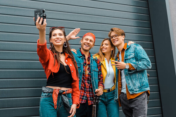 stylish smiling hipsters taking selfie on camera