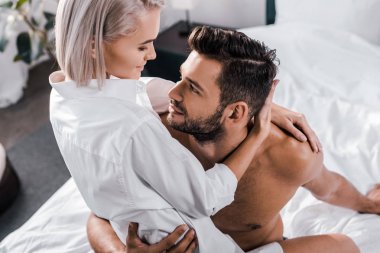 tutkulu genç kadının erkek yatak odasında oturup yüksek açılı görünüş