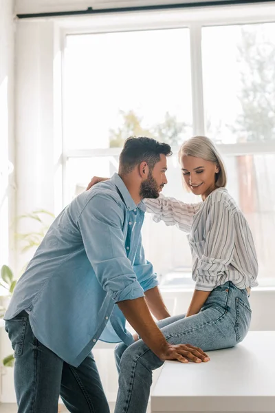 Side View Smiling Young Couple Hugging Kitchen While Girlfriend Sitting — Stock Photo, Image