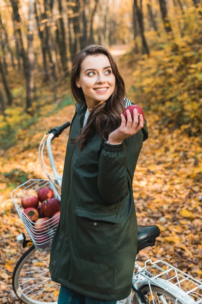 Привлекательная Молодая Женщина Яблоком Стоящая Возле Велосипеда Осеннем Лесу — стоковое фото
