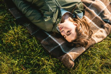 güzel genç kadının kapalı gözler üzerinde battaniye açık havada döşeme ile yüksek açılı görünüş 