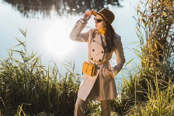 Elegante Frau Mit Hut Und Trenchcoat Posiert Teich Park — kostenloses Stockfoto