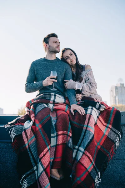 美しい若いカップルの格子縞のカバーと屋上に赤ワインを飲むの底面図 — ストック写真