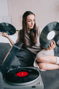 diskler için vinil plak çalar evde kanepede tutan güzel genç kadın