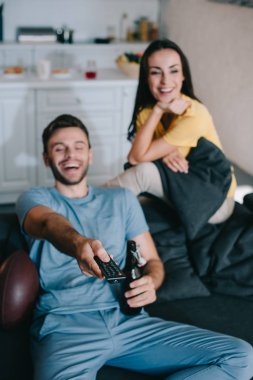 Amerikan futbolu oyunu evde izlerken mutlu genç çift