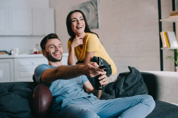 Riendo Joven Pareja Viendo Americano Fútbol Partido Casa —  Fotos de Stock