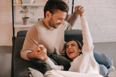 evde kanepede oynayan güzel genç çift