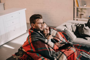 güzel genç çift kanepede rahatlatıcı ve tarassut tv birlikte ile ekose kaplama sırasında