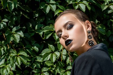 Güneş ışınları yüz ve arka plan, yeşil yaprakları ile güzel genç kadın 