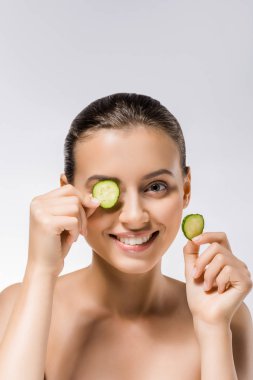 young smiling woman with cucumber slice on eye clipart