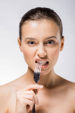 young beautiful woman holding silver fork near teeth  clipart