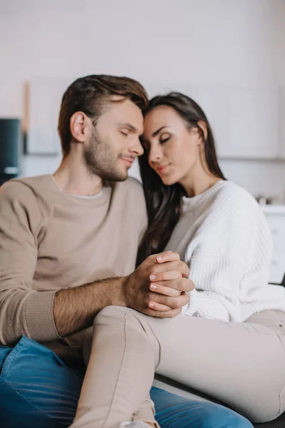 Happy Young Couple Cuddling Holding Hands Couch Home — Stock Photo, Image