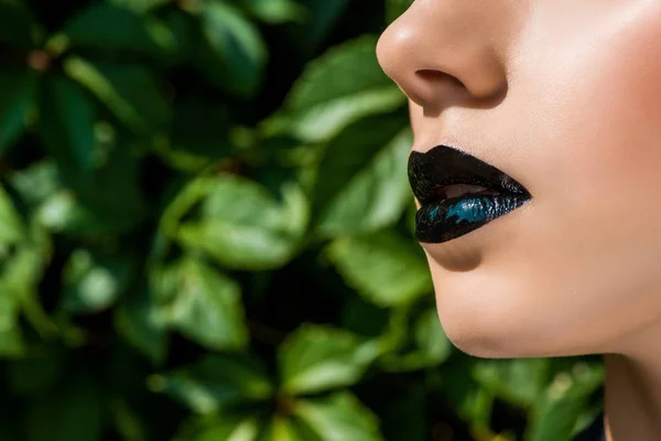 緑の背景に女性の黒い光沢のある唇のクローズ アップ — ストック写真