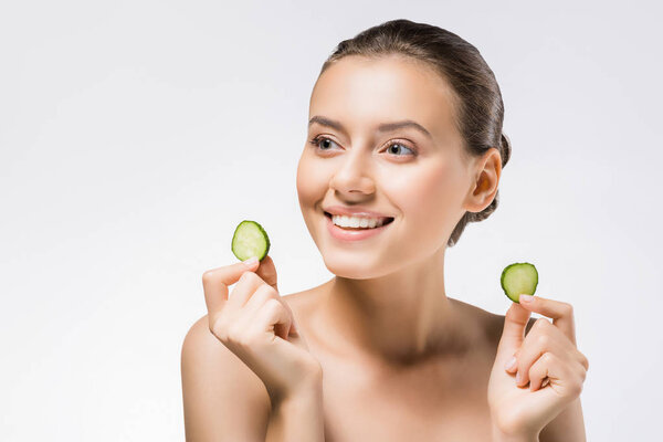 young smiling woman holding cucumber slices 