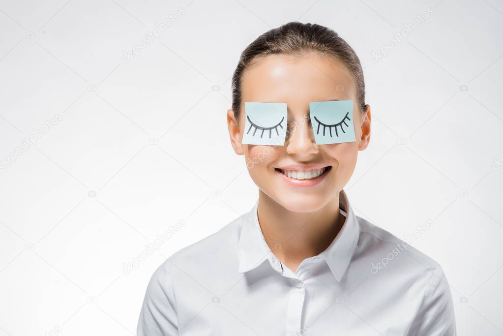 young smiling woman with sticky notes on eyes and drawn eyelashes