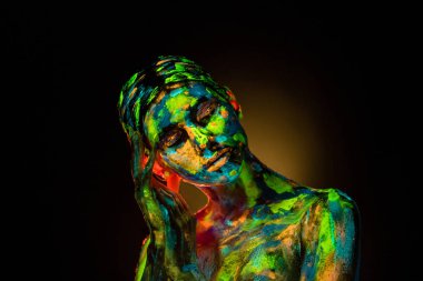 portrait of beautiful woman with colorful ultraviolet paints on body on black backdrop clipart