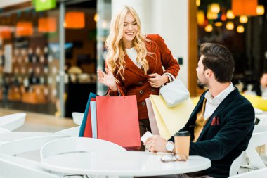çekici kadın erkek Alışveriş Merkezi kafede sallayarak poşetler