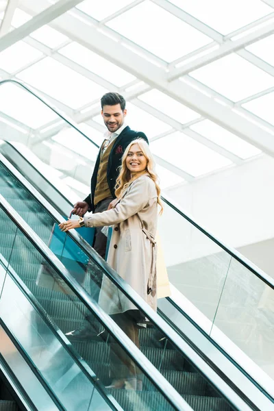 Happy Elegant Couple Standing Escalator — Free Stock Photo