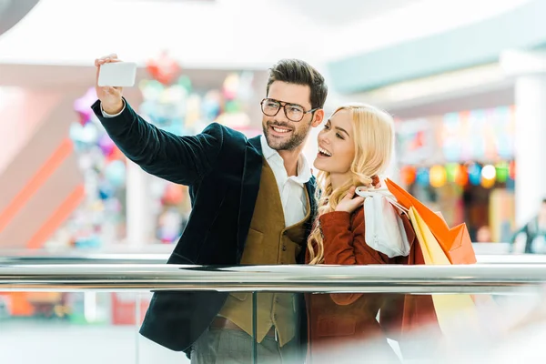 Joven Pareja Emocionada Con Bolsas Compras Tomando Selfie Teléfono Inteligente — Foto de Stock