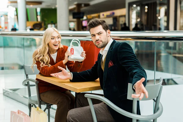 Excited Shopaholic Showing Bag Sale Tag Confused Boyfriend — Stock Photo, Image