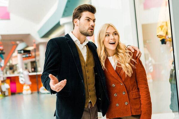 young emotional couple spending time in shopping center