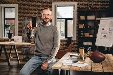 casual işadamı smartphone boş ekran ile çatı ofiste tutan görünümünü kırpılmış