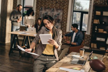 çalışma ve smartphone loft Office iş arkadaşlarınızla konuşurken meşgul rahat iş kadını