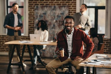 Afro-Amerikan rahat işadamı arkasında çalışma çatı office meslektaşları ile kahve içme