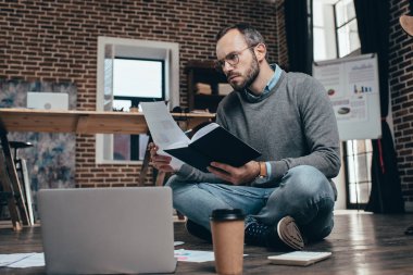 bilgisayar ile katta oturan ve modern loft Office proje üzerinde rahat işadamı konsantre