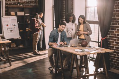 dizüstü bilgisayar kullanarak ve birlikte loft Office proje üzerinde rahat iş adamları