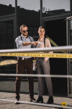 bir şey ortağına gösterilen erkek dedektif