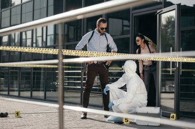 Dedektifler ve koruyucu elbise ve lateks eldiven olay yerinde iletişim kriminoloji uzmanı