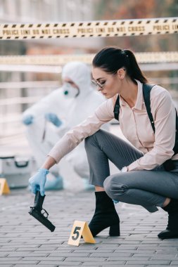 kadın dedektif alarak silahı olay yerinde arkasında kriminolog ile bir ipucu olarak