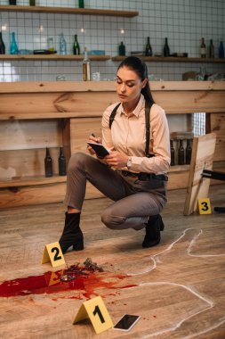 female detective collecting data and investigating crime scene clipart