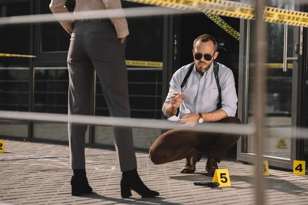 Sitting Male Detective Sunglasses Smoking Looking Crime Scene Standing Partner — Free Stock Photo