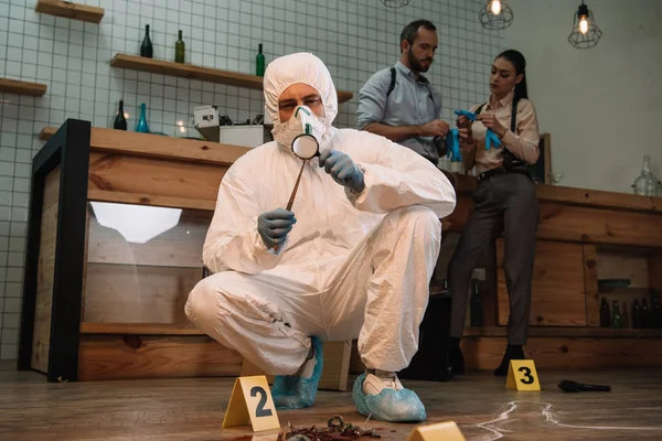 Forensic Investigator Examining Evidence Magnifying Glass Crime Scene Colleagues Working — Stock Photo, Image