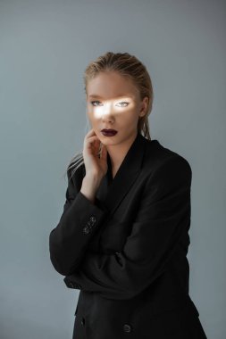 moda kız formal giyim gri izole yüzündeki ışık demeti ile poz