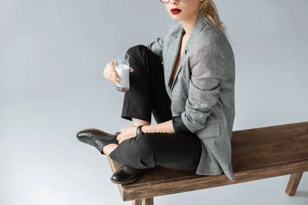 Vista Cortada Mulher Elegante Segurando Vidro Leite Enquanto Sentado Banco — Fotografia de Stock