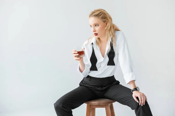 Fashionable Blonde Woman Glass Whiskey Sitting Stool Isolated Grey — Free Stock Photo