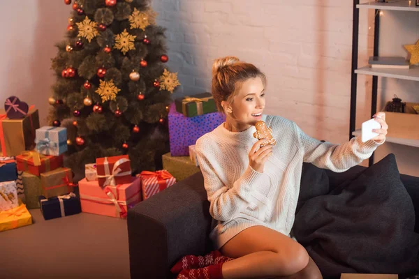 Young Blonde Woman Posing Gingerbread Cookie Taking Selfie Smartphone Christmas — Stock Photo, Image