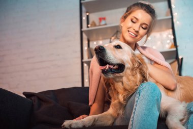 kanepede oturan ve golden retriever köpek Noel zamanda sarılma güzel mutlu sarışın genç kadın