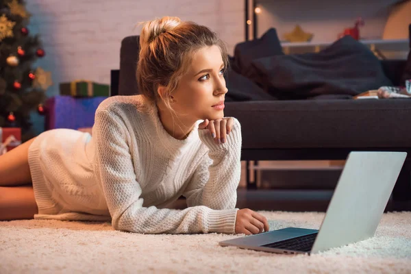 Pensive Young Blond Woman Lying Floor Using Laptop Christmas Time — Stock Photo, Image