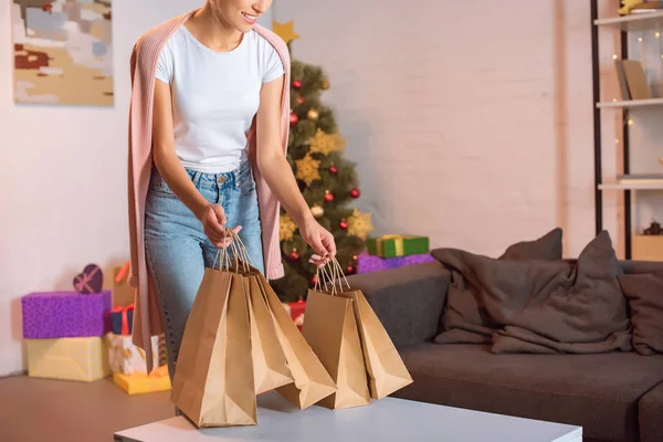 クリスマスの時に若い女性クリスマス キャリー ショッピング バッグを笑顔のトリミング ビュー — ストック写真