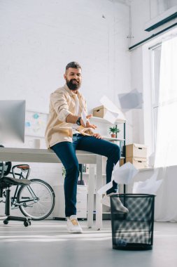 Kağıtları modern ofis çöpe atma neşeli ofis çalışanı 