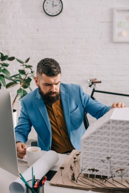 kahve tutarak ve Office proje üzerinde formal giyim yetişkin erkek mimar odaklı