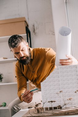 ev modeli işaret ve Office proje üzerinde sakallı yetişkin erkek holding mimar, odaklı 